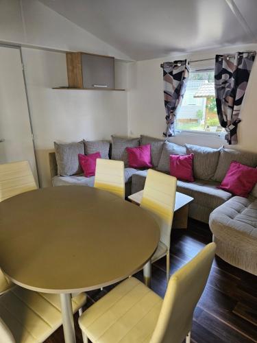 un salon avec une table et un canapé dans l'établissement Mobilhome, à Quend