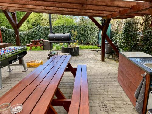 two wooden picnic tables in a backyard with a grill at Privát Adriana in Kremnica