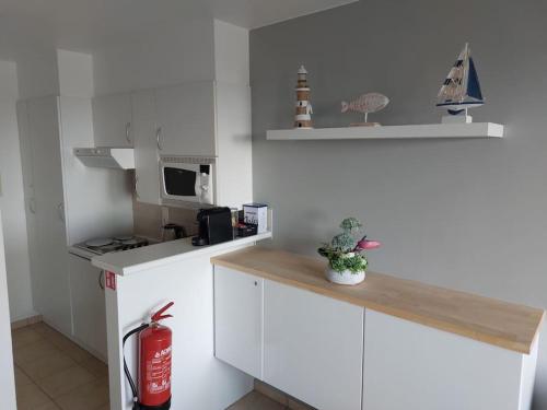 a white kitchen with a counter and a microwave at Studio Pura Vida in Ostend