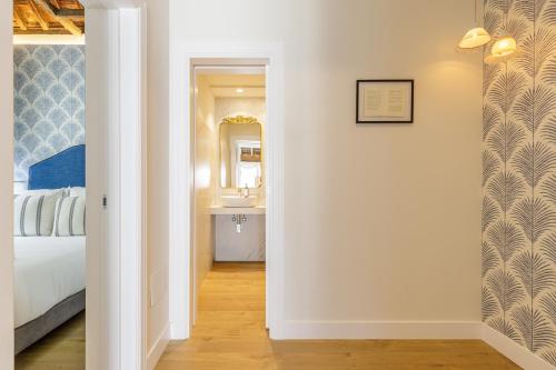 a hallway leading to a bedroom with a bed and a sink at Palacio Vegafuente by Caleta Homes in Málaga