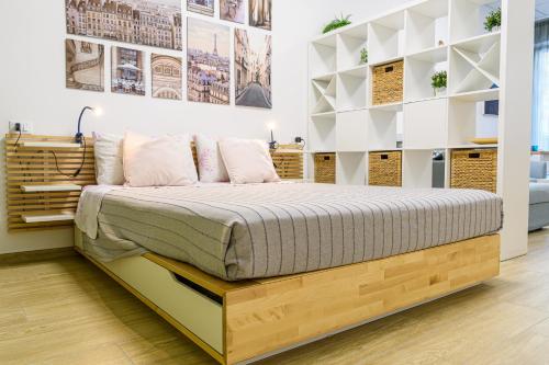 a bed in a room with white walls and shelves at Open Space Romagna 14 in San Benedetto del Tronto