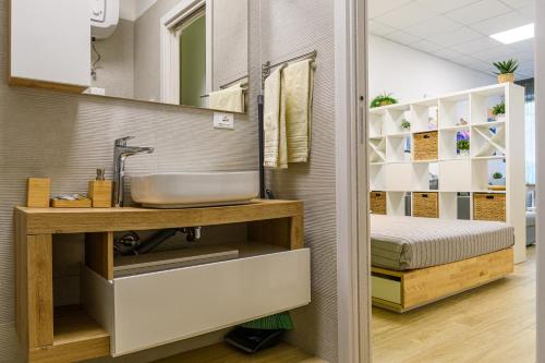 a bathroom with a sink and a bed at Open Space Romagna 14 in San Benedetto del Tronto