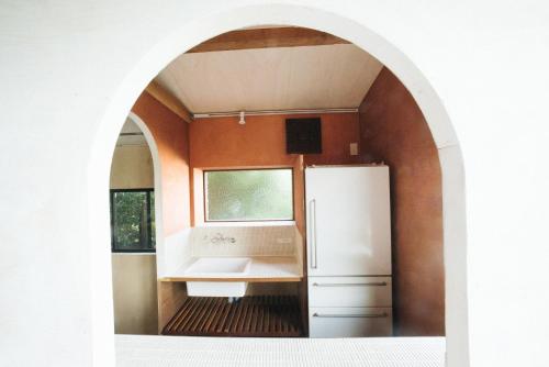 an archway in a kitchen with a white refrigerator at Villa Yumigahama in Minamiizu