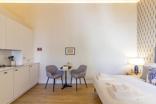 a room with a bed and two chairs and a table at Palacio Vegafuente by Caleta Homes in Málaga