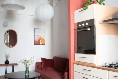 un salon avec un canapé rouge et une table dans l'établissement Bel et grand appartement Quais de la Fontaine, à Nîmes