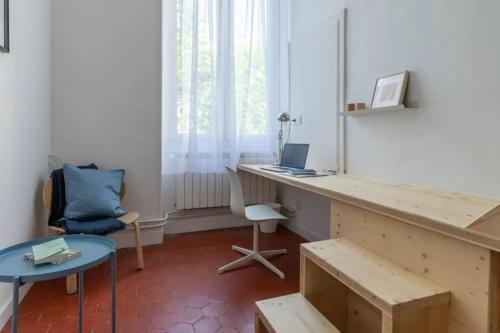 Cette chambre comprend un bureau avec un ordinateur portable et une chaise. dans l'établissement Bel et grand appartement Quais de la Fontaine, à Nîmes