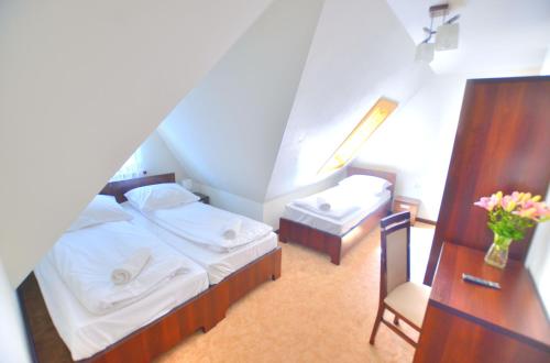 a small bedroom with two beds and a desk at Biały Dworek in Biały Dunajec