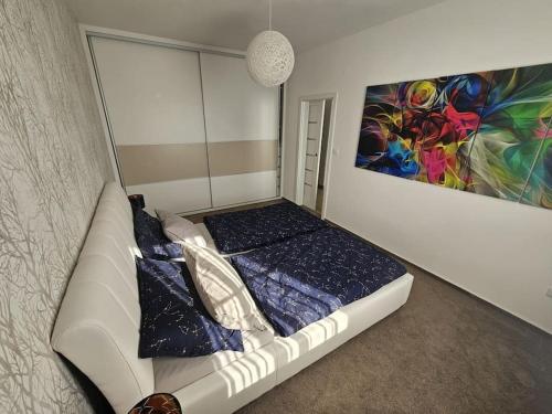 a bed in a room with a painting on the wall at Apartmán Rataj in Chrudim