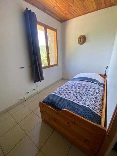 une chambre avec un lit dans une pièce avec une fenêtre dans l'établissement Les Ailes, à La Piarre