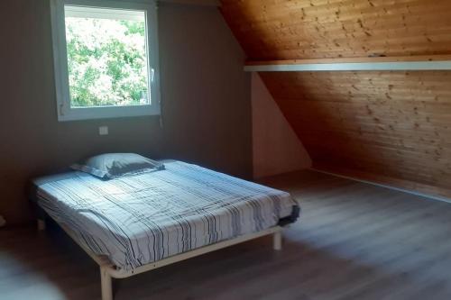 une chambre avec un lit dans une pièce avec une fenêtre dans l'établissement Maison familiale au Hézo, à Le Hézo