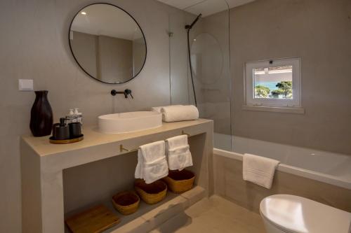 a bathroom with a sink and a mirror and a tub at Masana Algarve in Albufeira