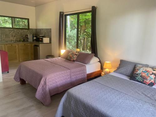 a bedroom with two beds and a window at Villas en el Bosque in Ojochal
