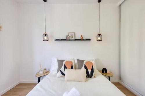 - une chambre blanche dotée d'un lit avec des chaussures dans l'établissement T2 parisien- 1 min à pied du Métro Ligne 13 & 14, à Paris