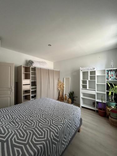 - une chambre avec un lit doté d'un couvre-lit noir et blanc dans l'établissement Maison mitoyenne proche Avignon, à Avignon