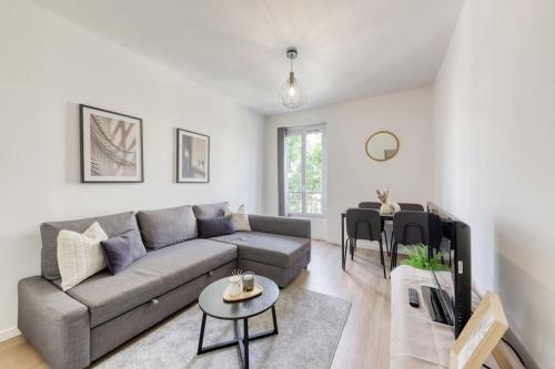 un salon avec un canapé et une table dans l'établissement T2 parisien- 1 min à pied du Métro Ligne 13 & 14, à Paris