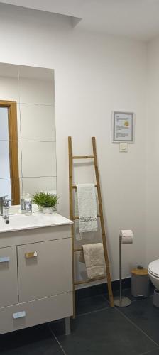 a bathroom with a towel rack next to a sink at Zambujeiraseahouse - 100m da praia in Zambujeira do Mar