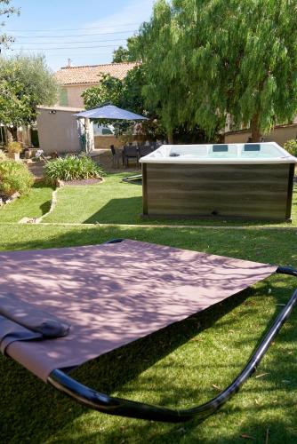 a trampoline on the grass in front of a tub at La Provençale - Jacuzzi, BBQ, jardin & clim in Toulon