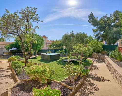 a garden with trees and a table in the middle at La Provençale - Jacuzzi, BBQ, jardin & clim in Toulon