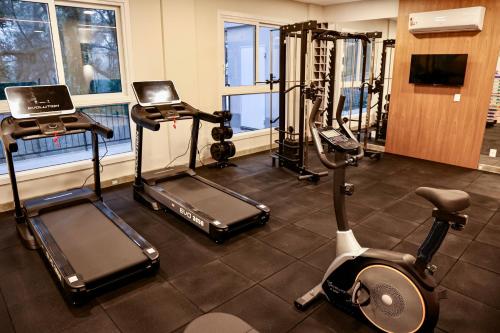 a gym with two treadmills and two exercise bikes at Sensacional Flat Serra Class - vista do Pôr do Sol in Canela