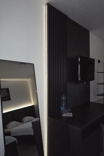 a reflection of a room with a bed and a mirror at Hotel Antika in Peje