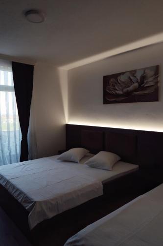 a bedroom with a bed with a light above it at Hotel Antika in Peje