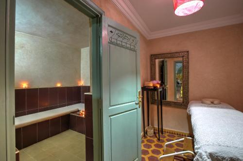 a room with a shower and a bed and a door at Riad Inaka in Marrakech