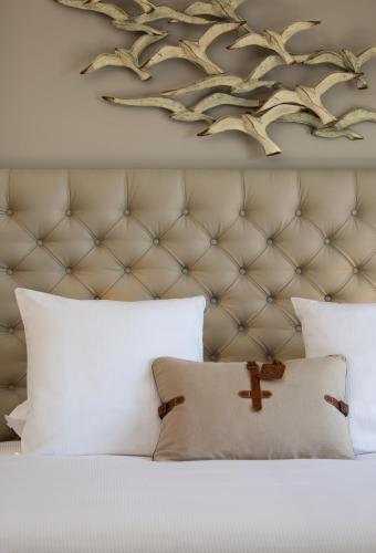 a bedroom with a white bed with a brown headboard at Grand Hotel Des Sablettes Plage, Curio Collection By Hilton in La Seyne-sur-Mer