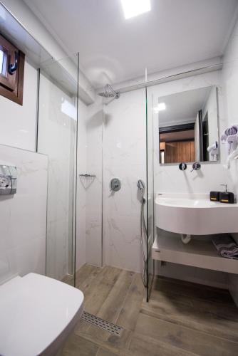 a white bathroom with a sink and a shower at Chasapis Luxury Apartments&Studios in Vourvourou