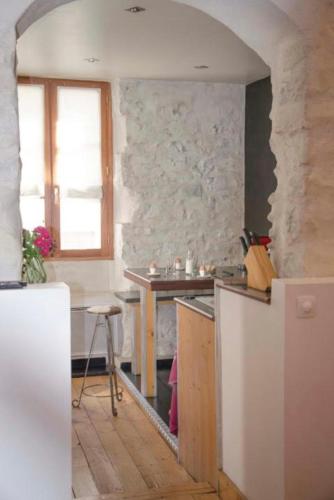 - une cuisine avec un mur en pierre et une table dans l'établissement L'original- Duplex de charme, à Biarritz