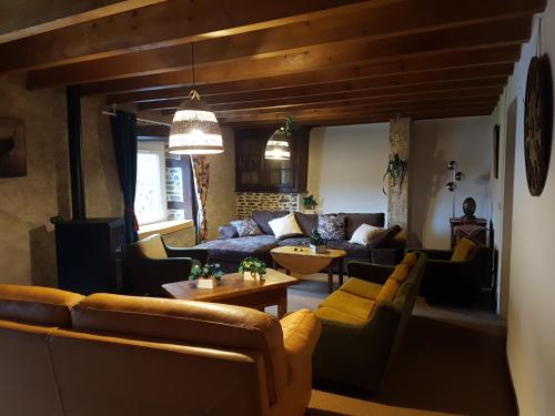 a living room with a couch and chairs and a table at La Cadette des 2 Frangines in Mazerat-Aurouze