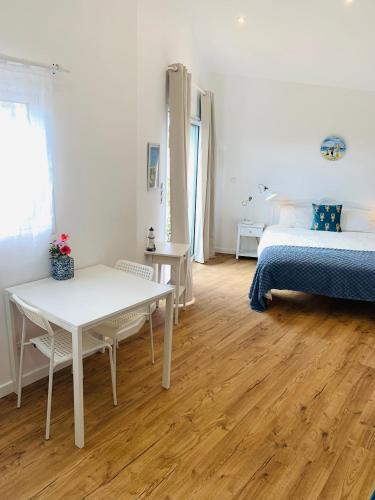 una stanza con un tavolo bianco e un letto e un letto e un tavolo di Charmante maisonnette neuve proche Thalasso a Sainte-Marie-de-Ré
