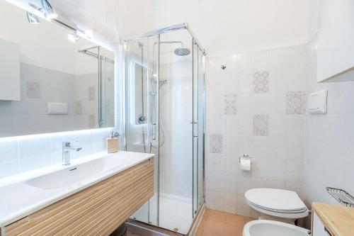 Un baño con ducha, lavabo e inodoro. en Villa Vinghi - Villasimius, en Villasimius