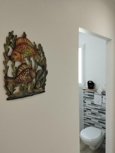 a painting of fishes on the wall of a bathroom at Casa Adam's in Saint-Jean-le-Thomas