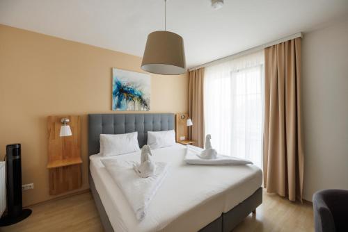 a bedroom with a large white bed with two ducks on it at Pension Laubenhof in Mörbisch am See