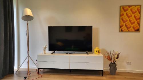 a flat screen tv sitting on top of a white dresser at Lego Fans Аpartment #3 Billund Center in Billund