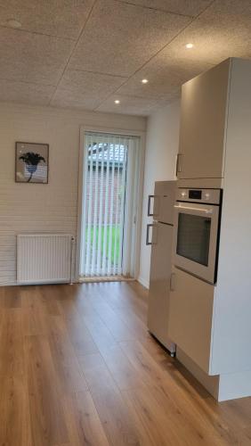 an empty room with a kitchen with a refrigerator at Lego Fans Аpartment #3 Billund Center in Billund