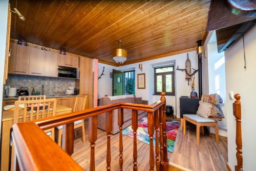 a kitchen and living room with a wooden staircase in a house at Montanhas do Xisto - Solar do Xisto Nascente in Candal