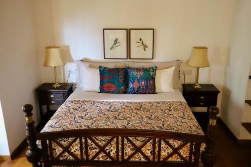 a bedroom with a bed with two lamps and two pillows at Bawlana Estate - Kandy in Kandy