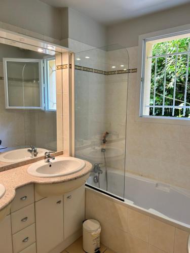 une salle de bain avec un lavabo, une douche et une baignoire dans l'établissement Splendide villa au cœur du Golf Lacanau Océan, à Lacanau-Océan