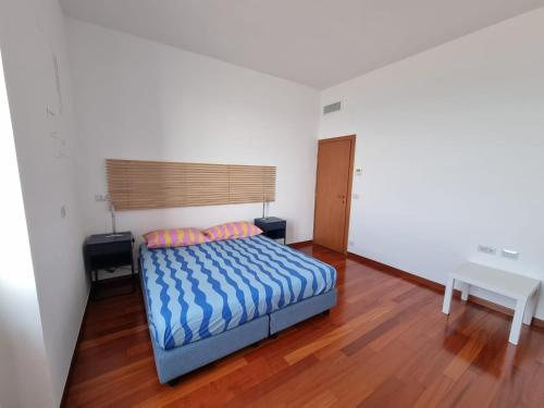 a bedroom with a bed and a wooden floor at Seafront Holidays & Workstays in Molfetta