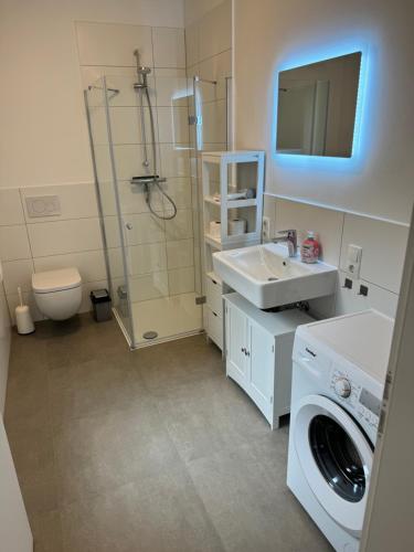 a bathroom with a sink and a washing machine at Haus Dünenweg in Achim