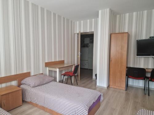 a room with two beds and a table and a television at Noclegi Ali in Wałbrzych