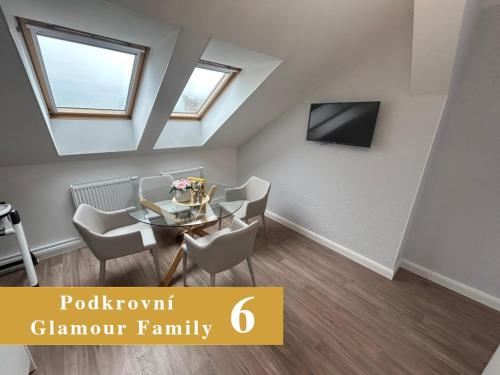a room with a table and chairs and a tv at EFIPA Glamour Apartments in Plzeň