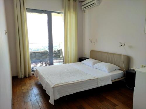 a bedroom with a bed and a large window at Nature Escape Amazing Sea View in Budva
