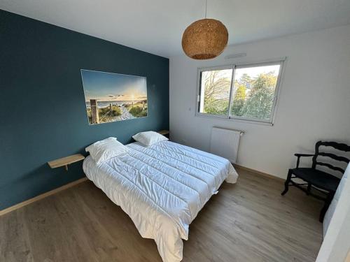 une chambre avec un lit et une chaise dedans dans l'établissement Lokentaz- Maison Familiale, à Saint-Gildas-de-Rhuys