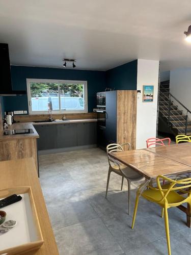 une cuisine avec une table et des chaises jaunes dans une pièce dans l'établissement Lokentaz- Maison Familiale, à Saint-Gildas-de-Rhuys
