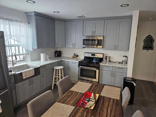Una cocina con gabinetes blancos y una mesa de madera. en Cozy & Relax Airb&b LLC, en Brooklyn