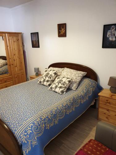 a bedroom with a bed with a blue comforter and pillows at FLORIDE in Le Mériot