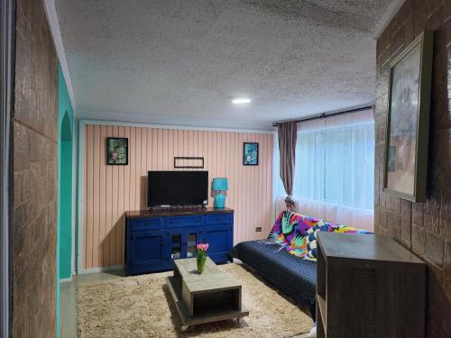 a living room with a couch and a tv at Departamento Constitución in Constitución