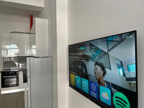 a flat screen tv hanging on a wall in a kitchen at Ameti - Ground Floor Comfort Suites - Spacious & Modern in Orikum